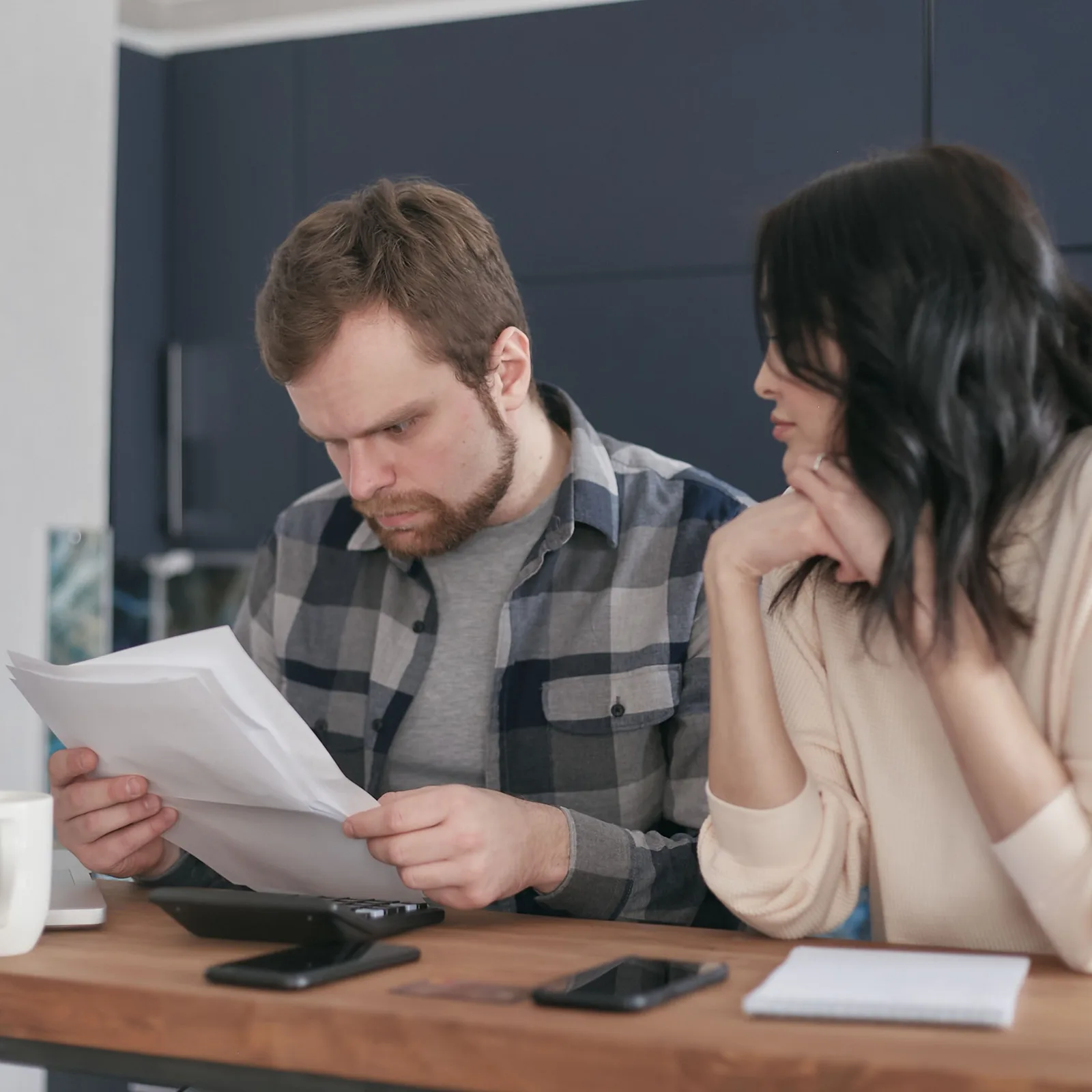 Un couple compare ses relevés bancaires à un bureau avant de changer de banque